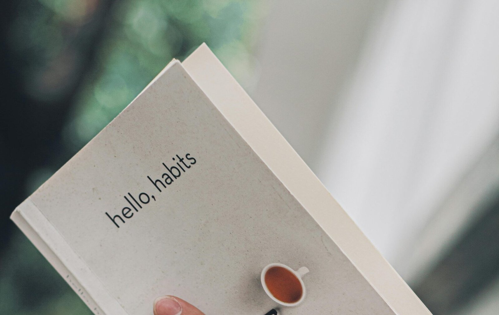 Photo of a journal titled hello, habits used to illustrate how habits form faster when repeated in the same context with stable cues.